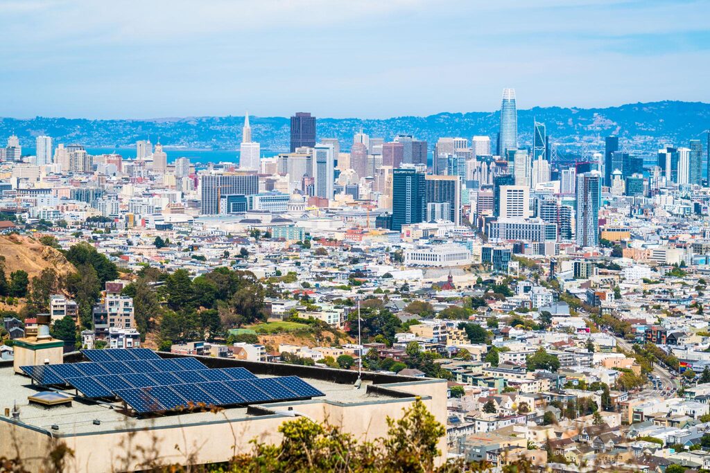 California city skyline with rooftop solar panels representing climate regulation, ESG compliance, and renewable energy transition